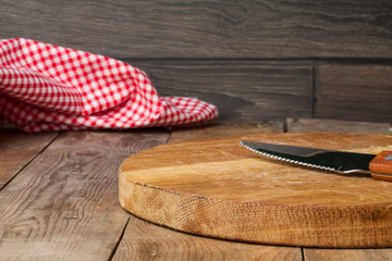 Rustic background with wooden table, knife and tablecloth