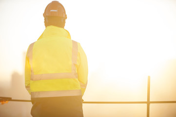 Worker at the construction site and sunrise background