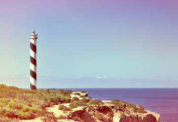 Black and white striped lighthouse on a cliffcoast. Beacon and copy space.