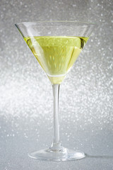 Green apple cocktail on glitter background
