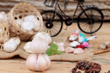 Raw garlic has health benefits on wood background.