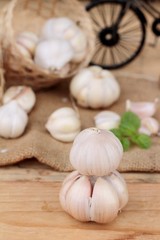 Raw garlic has health benefits on wood background.