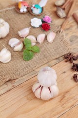 Raw garlic has health benefits on wood background.