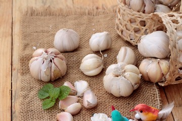 Raw garlic has health benefits on wood background.