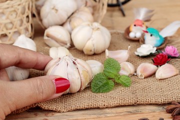 Raw garlic has health benefits on wood background.