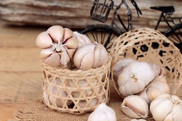 Raw garlic has health benefits on wood background.