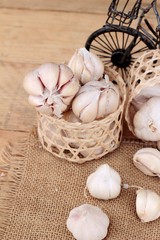 Raw garlic has health benefits on wood background.
