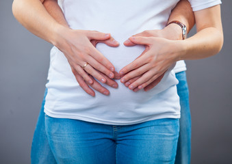 Waiting for baby. Happy man hugging his pregnant woman