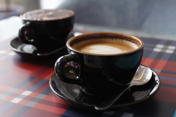 Coffee in black cup on wood table