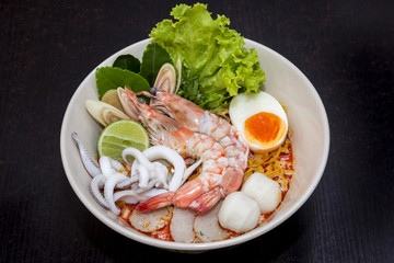 close up. thai noodle seafood, eggs, fish ball in a cup on dark