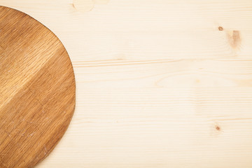 Empty round cutting board on a wooden table.Top view