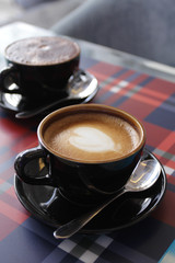 Coffee in black cup on wood table