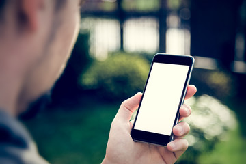 Man using mobile smartphone. Shot with third-person view, behind shoulder, blank screen