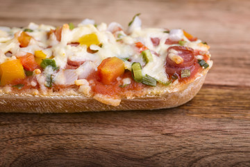 macro baked baguette with salami, cheese and vegetable