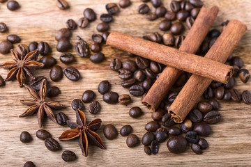 coffee beans, cinnamon and star anise on wood