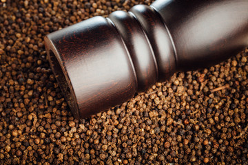 pepper mill on peppercorns background