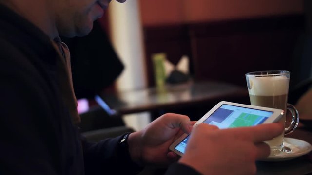 Young man with tablet computer exploring map during travel trip