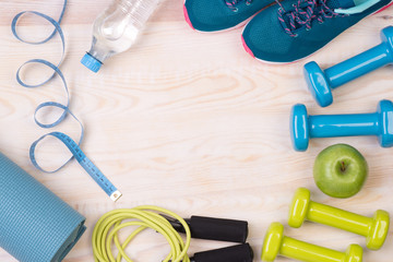 Fitness equipment on wooden background with copy space