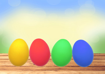 Colorful Easter eggs on wooden table over nature background
