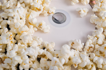 Closeup pile of white fluffy popcorn with dvd disc in the middle