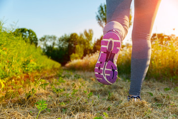 Woman running at sunset in a field