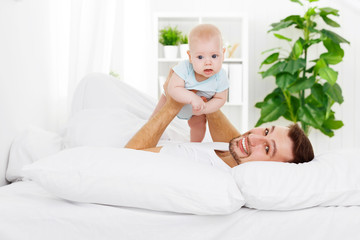 Obraz na płótnie Canvas happy family father and baby on bed