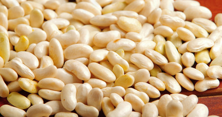 Lots of peeled lima beans lying spread out over wooden surface