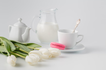 Fototapeta na wymiar White tulips with tea and sweets