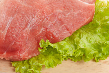 Raw pork on cutting board and vegetables