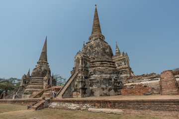 Fototapeta premium Teilansicht der Tempelanlagen der alten Königsstadt Ayutthaya in Thailand vor blauem Himmel