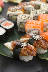 Traditional Japanese food - sushi, rolls and nigiri over black background