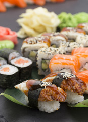 Traditional Japanese food - sushi, rolls and nigiri over black background