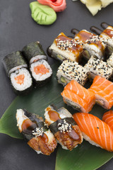 Traditional Japanese food - sushi, rolls and nigiri over black background