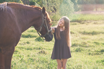 Girl stroking her horse and smiling