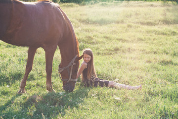 Girl and her horse on the sunlit field
