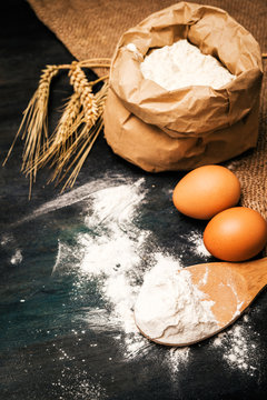  Flour and eggs on black table. Cooking process