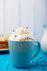 Blue ceramic cup of coffee with whipped cream