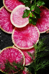 Food background: round slices of watermelon pink radish, dill, p