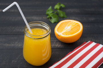 Fresh orange Juice in a Glass Jar with a plastic tube, half an O