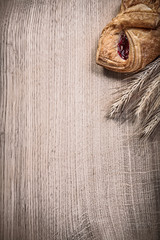Ripe wheat rye ears baked rolls on wooden board