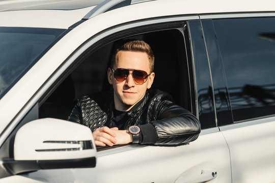 Fashionable Handsome Man in Sunglasses Sitting in his Luxury on Driver Seat. Luxury Life. Lifestyle photo. Ideal for commercial