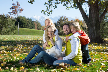 Naklejka na ściany i meble Parents with two children in autumn park