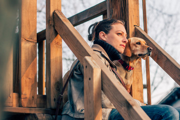 Woman and her dog sitting and looking at far distance