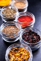 Obraz na płótnie Canvas Spices on black background in special jars. Food