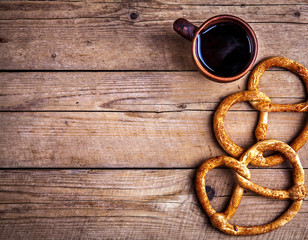 Delicious Breakfast, a pretzel with coffee on wooden background. The food, the drinks.