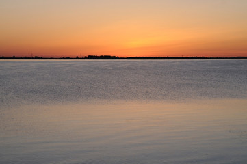 Fototapeta premium Sunset on a river/ Reflection of the sunset in calm waters of a lowland river (Northern Dvina), Arkhangelsk, Russia