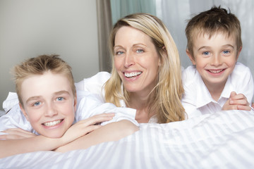 Mother And two Son Relaxing Together In Bed