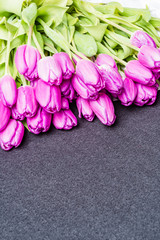 Anniversary pink tulip flower bouquet arranged on grey background