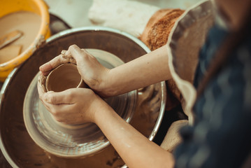 child working on potter's wheel
