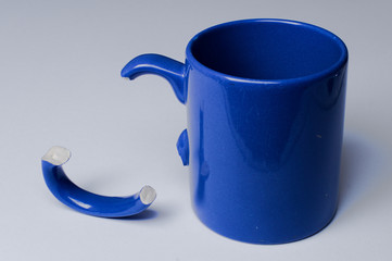 zerbrochene blaue Kaffeetasse mit abgebrochenem Henkel